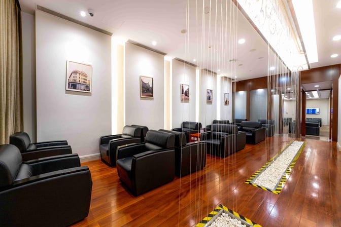 The seating area in the First Class Lounge at Shanghai Pudong International Airport features comfortable armchairs and wall art.