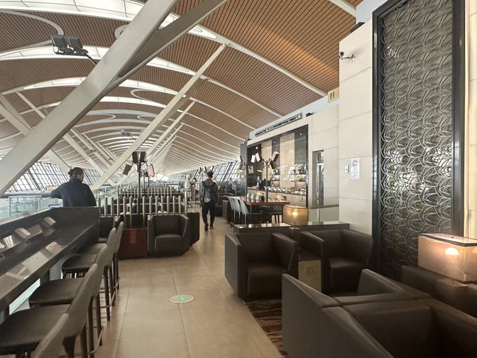 The seating area in No. 77 China Eastern Lounge at Shanghai Pudong International Airport offers various seating options with views of the terminal.