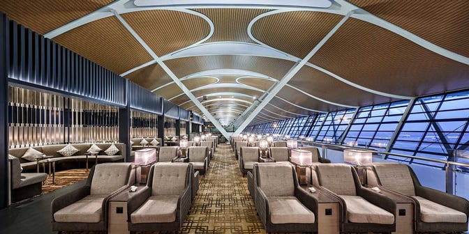 Seating in the No. 77 China Eastern Lounge at Shanghai Pudong offers individual chairs with side tables and views of the airport.