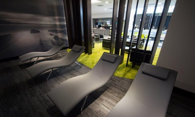 The Boru Lounge at Shannon International Airport features a relaxation area with reclined seating adjacent to a seating area with tables.