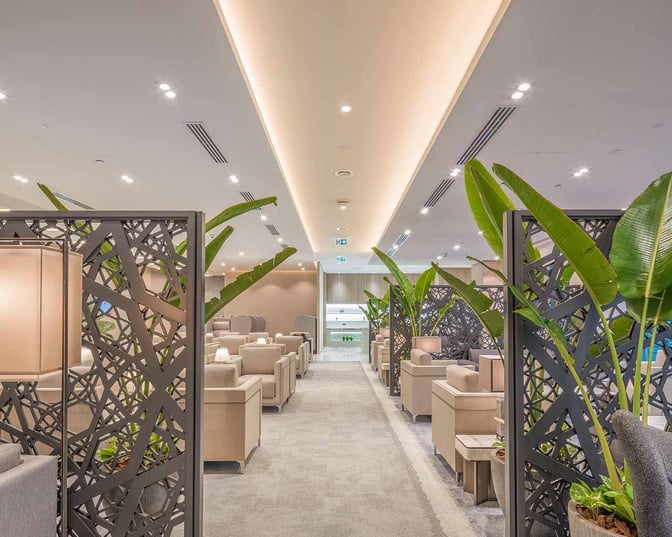 The seating area at Sharjah International Airport's lounge features comfortable chairs and decorative partitions for privacy and relaxation.