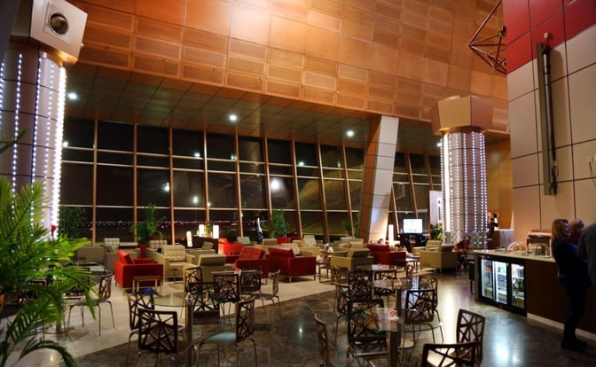 The Pearl Lounge at Sharm el-Sheikh International Airport features spacious seating with tables, a refreshment area, and large windows overlooking the tarmac.
