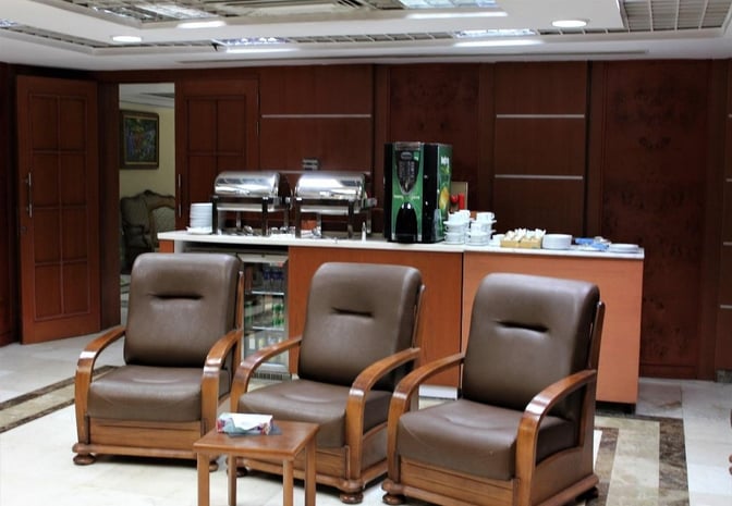 The Pearl Lounge at Sharm el-Sheikh International Airport Terminal 2 features a seating area with armchairs and a self-serve beverage and snack station.