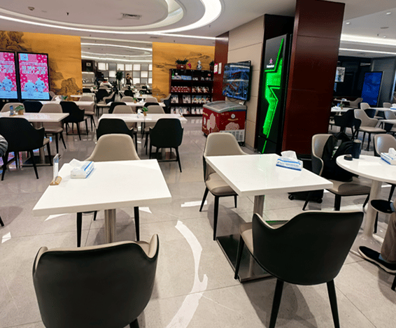 The seating area in the China Southern Lounge at Shenyang Taoxian International Airport features tables and chairs for dining and relaxation.