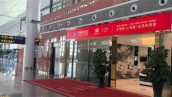 The entrance to the China Southern First/Business Class Lounge at Shenyang Taoxian Airport features a red carpet and visible seating area.