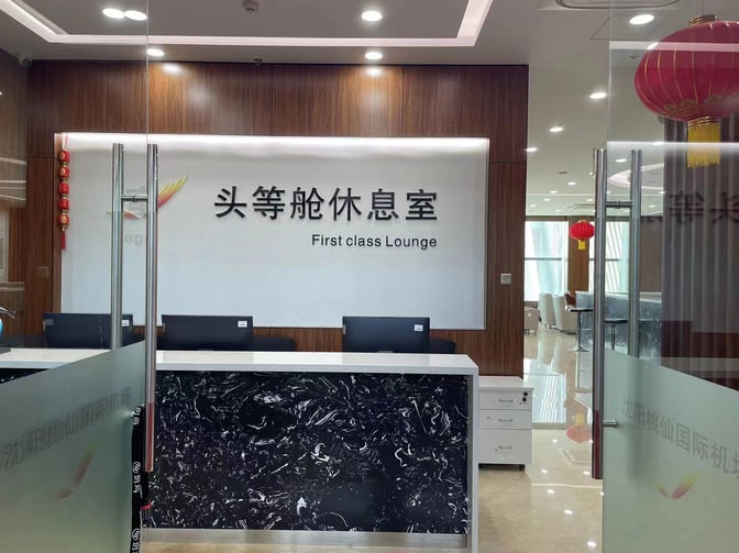 The entrance to the International First Class Lounge at Shenyang Taoxian International Airport features a reception desk and seating area.