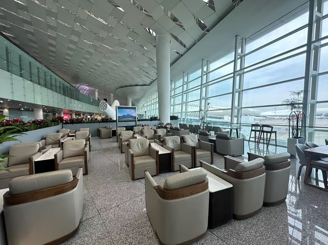The seating area in Shenzhen Bao'an International Airport's VIP Lounge offers comfortable chairs and tables with expansive airport views.