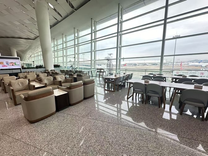 The International Business VIP Lounge at Shenzhen Bao'an Airport features comfortable seating and dining tables with expansive runway views.