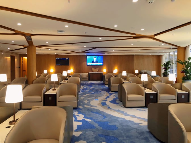 The seating area in Domestic VIP Lounge 3 at Shenzhen Bao'an International Airport features armchairs, side tables, and multiple TV screens.