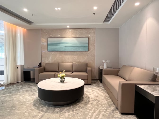 The Shenzhen Airport Domestic VIP Lounge 3 features a seating area with sofas and a central round table for relaxation.