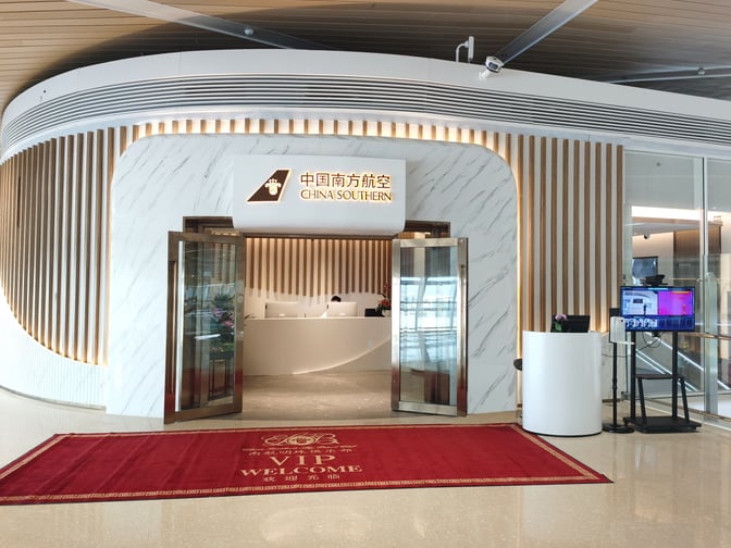 The entrance to the China Southern Guest Lounge at Shenzhen Bao'an International Airport features a reception desk and welcoming signage.