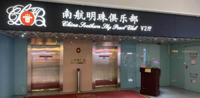 The entrance to China Southern Sky Pearl Club V2 Lounge at Shenzhen Bao'an International Airport features glass doors and a reception podium.