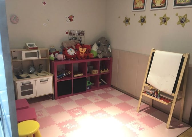 The children's play area in China Southern No. 2 Lounge at Shenzhen Airport features toys, a play kitchen, and an easel for drawing.