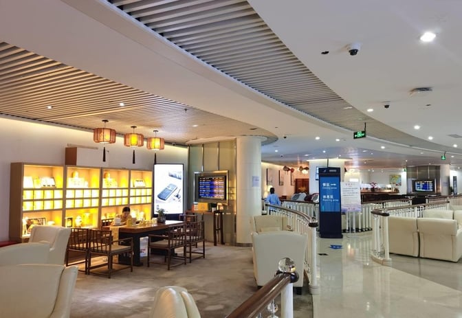 The China Southern No. 3 Lounge at Shenzhen Bao'an International Airport features a seating area with tables and informational displays.