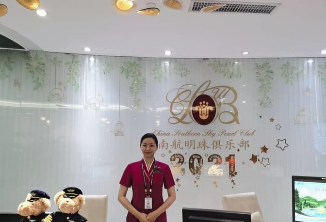 The reception area of China Southern No. 3 Lounge at Shenzhen Bao'an International Airport features a staff member and decorative elements.