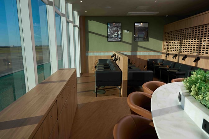 The seating area at W Café Lounge Maringa features booth seating with individual tables and views of the airport runway.