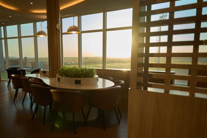 The W Café Lounge at Sílvio Name Júnior Regional Airport features a round seating area with power outlets and airport views.
