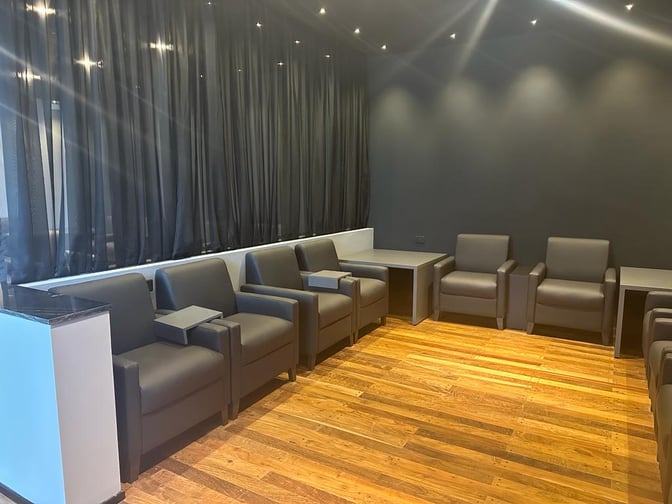 The seating area in the Sala VIP Black at Silvio Pettirossi International Airport features armchairs with side tables for passenger comfort.