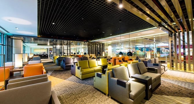 The seating area in Marhaba Lounge at Singapore Changi Airport features various armchairs arranged for passenger relaxation and comfort.