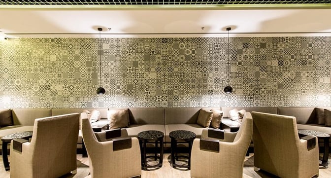 The seating area in Marhaba Lounge at Singapore Changi Airport features cushioned chairs and sofas with small tables for relaxation.