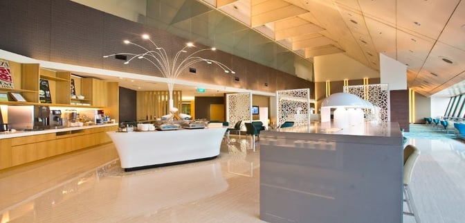 The Ambassador Transit Lounge at Singapore Changi Airport features a self-serve food area with various snacks and beverages available.