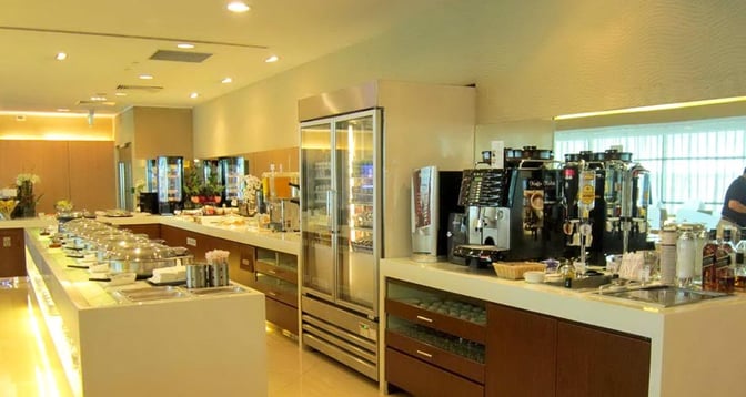 The SATS Premier Lounge at Singapore Changi Airport features a self-serve food and beverage area with hot dishes and coffee machines.