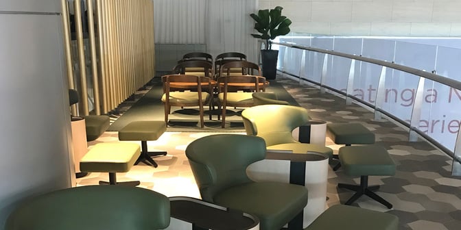 The seating area in BLOSSOM Lounge at Singapore Changi Airport features a mix of chairs and tables for passenger relaxation.
