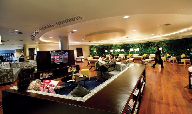 The Amedee Maingard Lounge at Sir Seewoosagur Ramgoolam International Airport features seating areas with a television and reading materials.