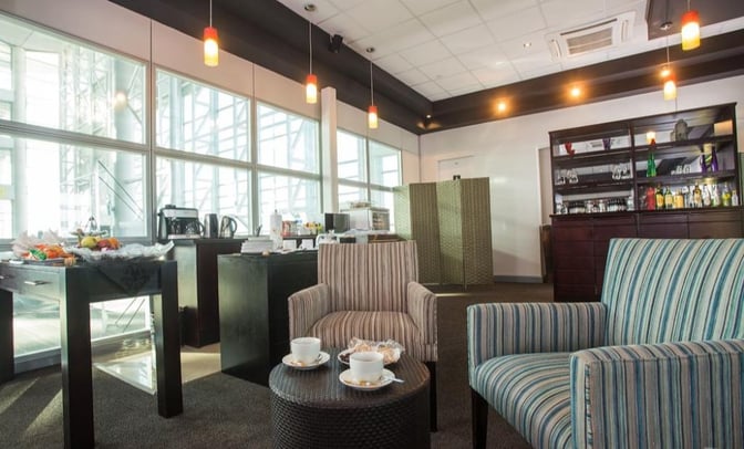 The Pula Lounge at Sir Seretse Khama International Airport features a seating area with complimentary beverages and snacks available for guests.