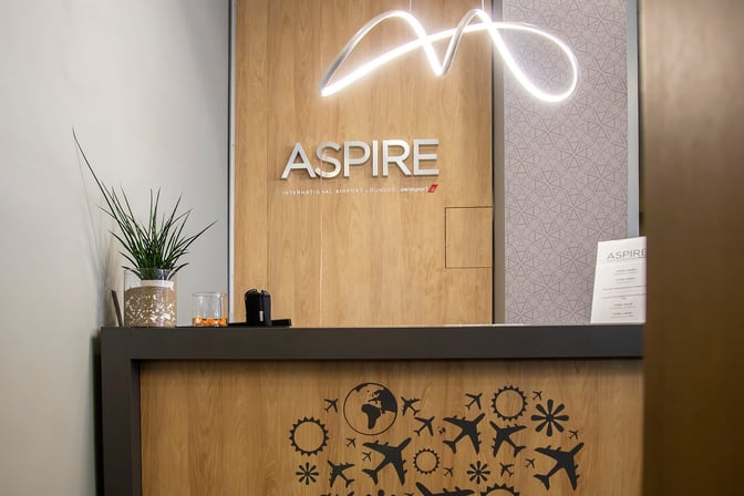 The entrance to the Vitosha Aspire Lounge at Sofia Airport features a reception desk with signage and decorative elements.