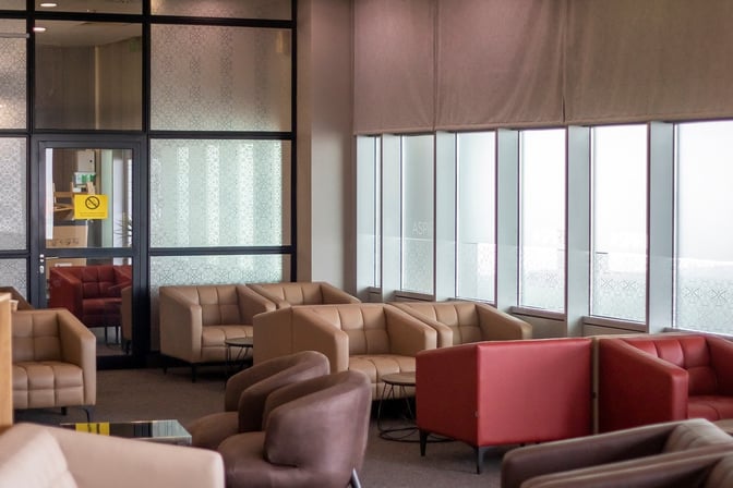 The seating area in Vitosha Aspire Lounge at Sofia Airport features comfortable armchairs and sofas arranged near large windows.