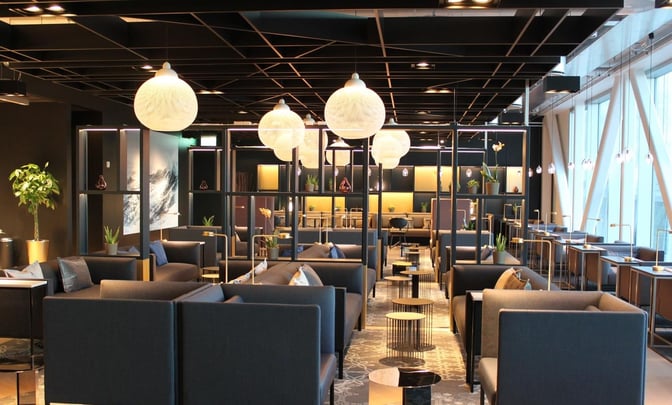The North Sea Lounge at Stavanger Airport features spacious seating areas with sofas, tables, and decorative plants for passenger relaxation.