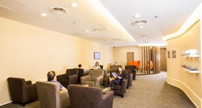 The Sky Lounge at Sultan Abdul Aziz Shah Airport features comfortable armchairs and a seating area for travelers to relax.