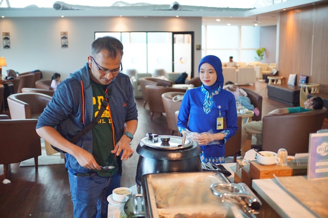 The Concordia Lounge at Sultan Hasanuddin International Airport features a self-serve food station with comfortable seating areas for travelers.