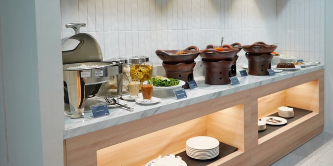 The Saphire Lounge at Sultan Thaha Airport features a self-serve buffet with hot dishes, salads, and condiments for travelers.