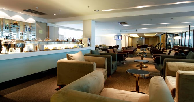 The Miracle First & Business Class Lounge at Suvarnabhumi Airport features a bar with self-serve food options and ample seating.