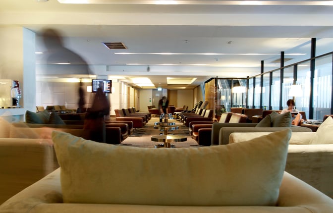 The seating area in the Miracle First & Business Class Lounge at Suvarnabhumi Airport features rows of armchairs and small tables.