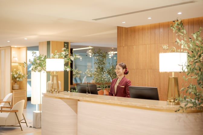 The reception area of The Coral Finest Business Class Lounge Cocoon at Suvarnabhumi Airport features a staffed desk and seating area.