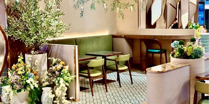 Booth seating in the Miracle First Class Lounge at Suvarnabhumi Airport Concourse C offers semi-private dining with decorative plant arrangements.