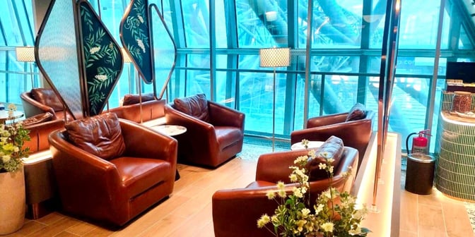 Comfortable seating in the Miracle First Class Lounge at Suvarnabhumi Airport Concourse C offers travelers a relaxing space with armchairs and small tables.