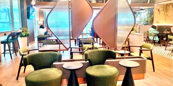 The seating area in the Miracle First Class Lounge at Suvarnabhumi Airport Concourse C features comfortable chairs and tables for relaxation and dining.