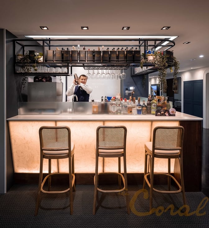 The bar at The Coral Finest Business Class Lounge in Suvarnabhumi Airport offers a selection of spirits with counter seating.