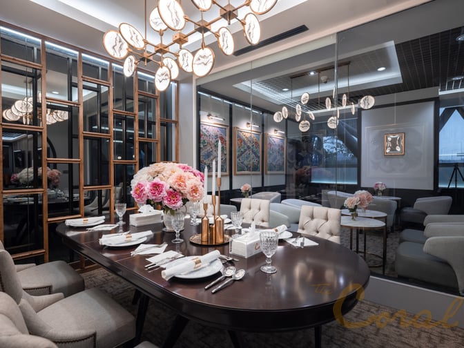 The Coral First Class Lounge at Suvarnabhumi Airport features a dining area with a set table and comfortable seating.