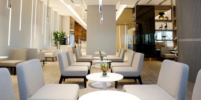 The seating area in the Miracle First Class Lounge at Suvarnabhumi Airport features arranged chairs and tables for passenger relaxation.