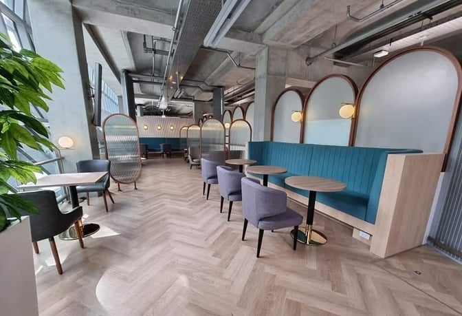 The seating area in Miracle Lounge at Suvarnabhumi Airport features booth and table seating with semi-private partitions for travelers.