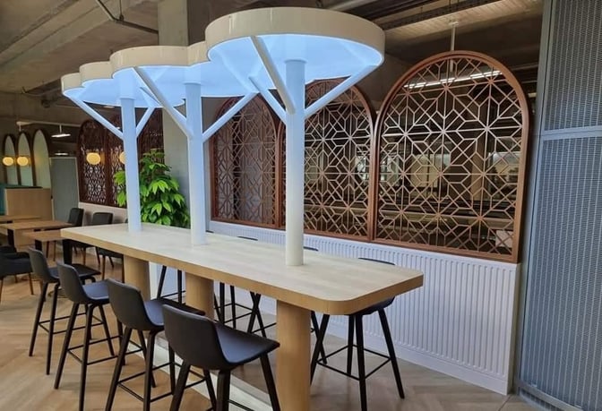 High-top communal tables with barstool seating are available in the Miracle Lounge at Suvarnabhumi Airport, offering a space for socializing.