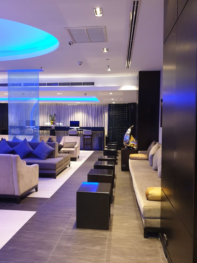 The Oman Air First and Business Class Lounge at Suvarnabhumi Airport features spacious seating with couches and tables for travelers.