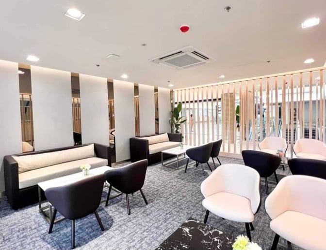 The seating area in the Miracle Business Class Lounge at Suvarnabhumi Airport features sofas and chairs with tables for relaxation.