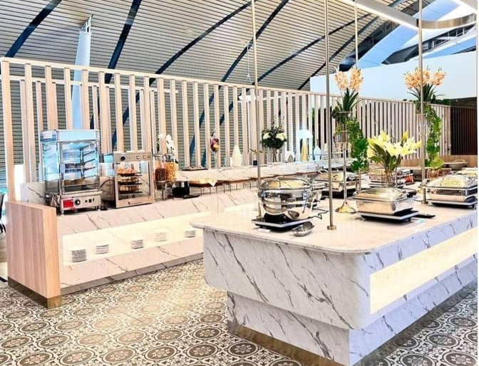 The Miracle Business Class Lounge at Suvarnabhumi Airport features a self-serve buffet area with hot dishes and beverage stations.