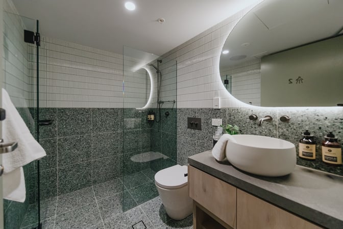 The Plaza Premium Lounge at Sydney Airport features a private shower room with a glass-enclosed shower, sink, and complimentary toiletries.